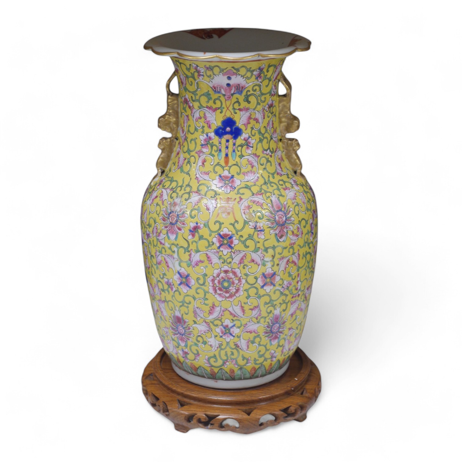 A late 19th century Chinese yellow ground porcelain vase, with gilt chilong handle, decorated with flowers and tendrils, iron red bands to the scalloped neck (including two stands), 35cm high. Condition - chip to top edg